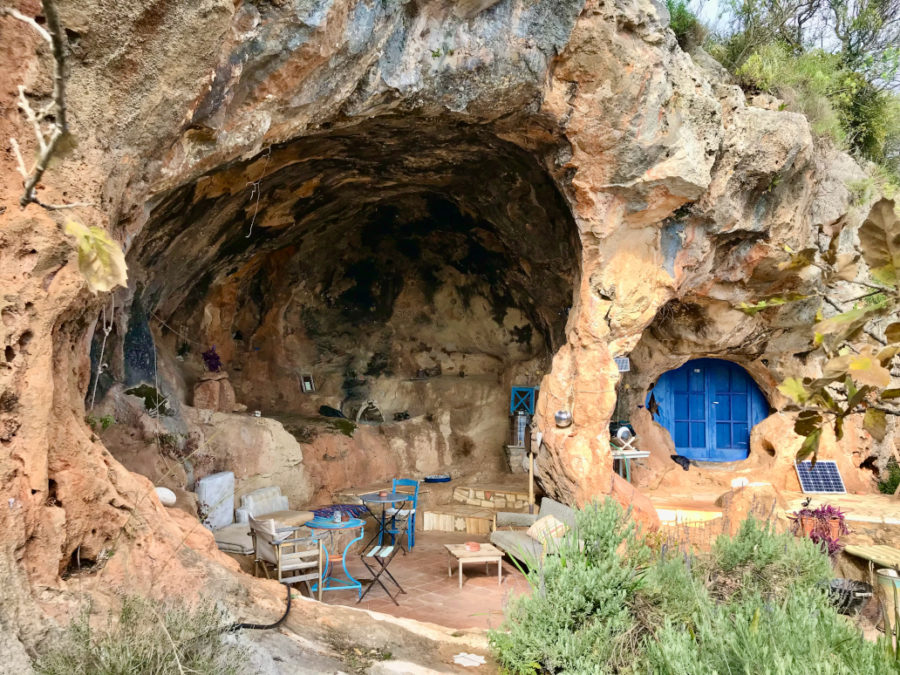 Prosiliako: Paula Permakultur Paradies. Auf dem Gelände befindet sich eine natürliche Höhle, die zum Schlafraum und Gemeinschaftsplatz ausgestaltet wurde. Der Höhleneingang wurde mit einer Blauen Tür geschlossen.